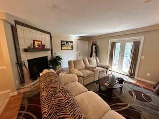 living room with hardwood / wood-style flooring, a fireplace, and french doors