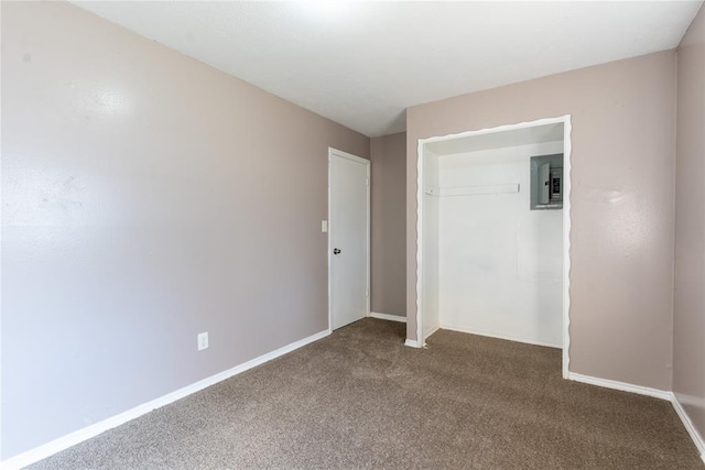 unfurnished bedroom with dark colored carpet, electric panel, and a closet