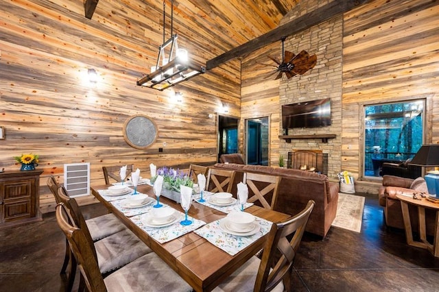 dining area featuring ceiling fan, wood ceiling, beamed ceiling, and a fireplace