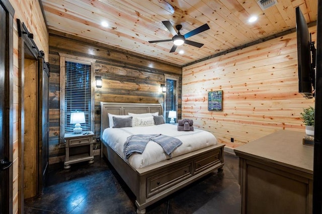 bedroom with ceiling fan, wooden ceiling, a barn door, and wooden walls