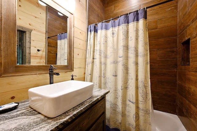 bathroom featuring vanity, wood walls, and shower / bath combination with curtain