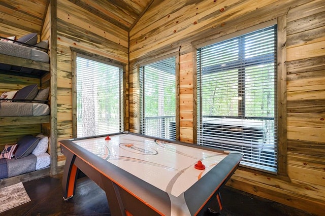 recreation room with lofted ceiling and wooden walls