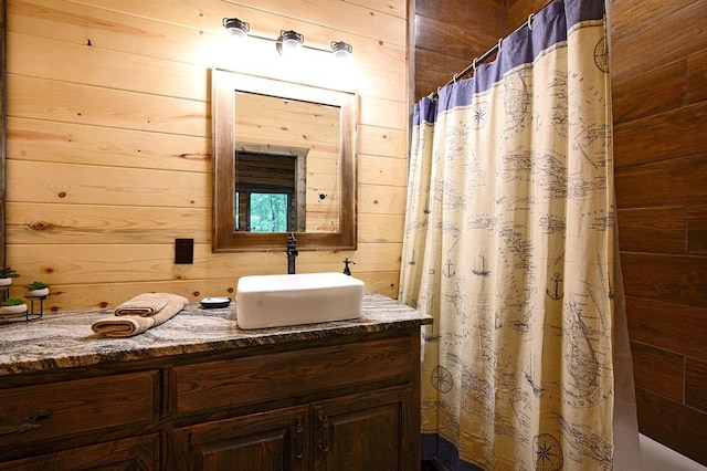 bathroom featuring vanity, a shower with curtain, and wooden walls