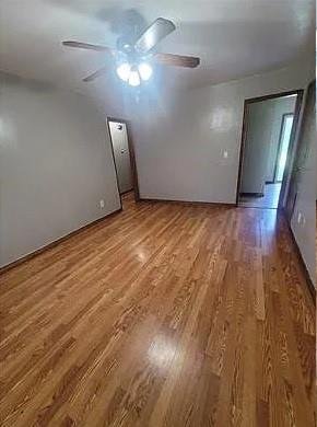 spare room with ceiling fan and hardwood / wood-style flooring