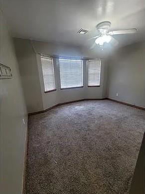 carpeted spare room featuring ceiling fan