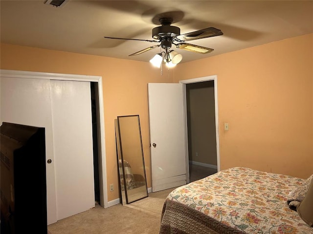 bedroom featuring light carpet, a closet, and ceiling fan