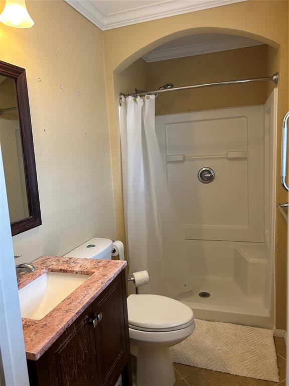 bathroom with tile patterned flooring, a shower with curtain, toilet, and crown molding