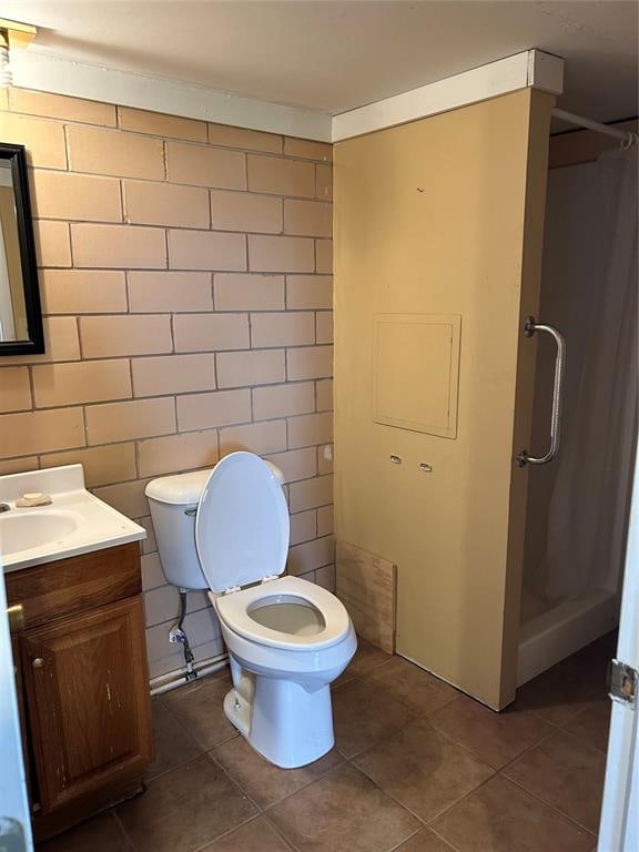 bathroom featuring tile patterned floors, curtained shower, vanity, and toilet