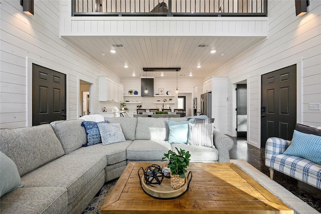 living room featuring wood walls and a towering ceiling