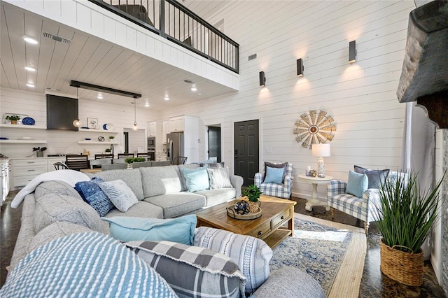 living room featuring wooden walls and a high ceiling