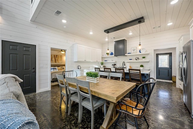 dining space featuring wood walls, ceiling fan, and wood ceiling