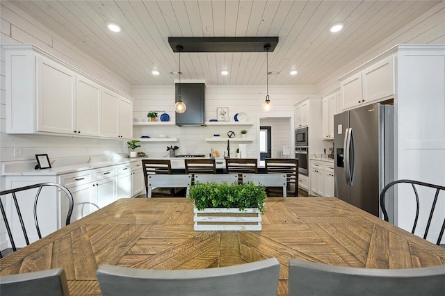 kitchen featuring tasteful backsplash, stainless steel appliances, extractor fan, pendant lighting, and white cabinets