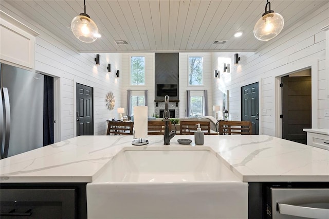 kitchen featuring a center island with sink and hanging light fixtures