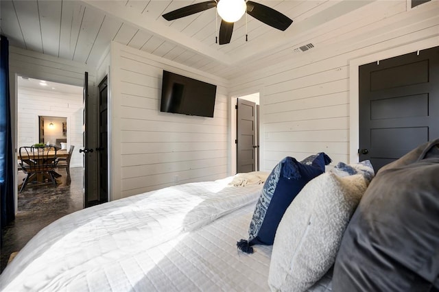 bedroom with ceiling fan and wooden walls