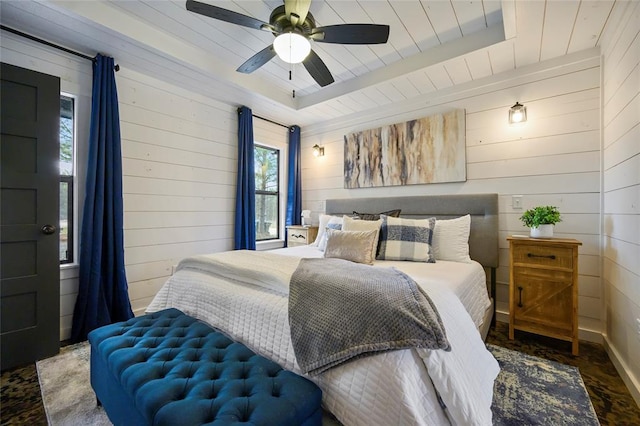 bedroom with ceiling fan, wooden walls, and wood ceiling