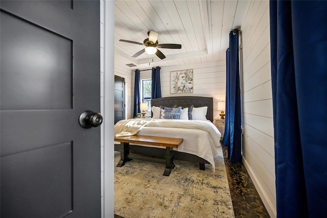 bedroom featuring ceiling fan and wood walls