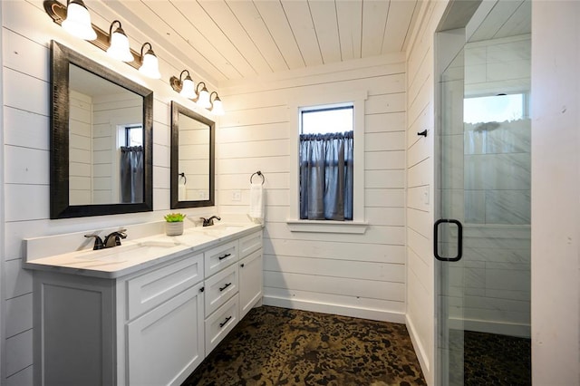 bathroom featuring plenty of natural light, vanity, a shower with shower door, and wooden walls