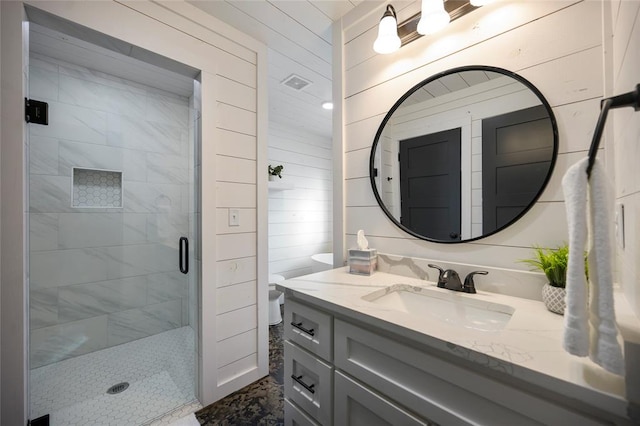 bathroom with wooden walls, a shower with door, and vanity