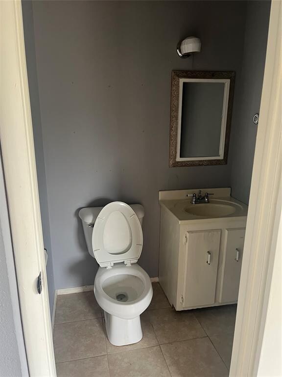 bathroom featuring tile patterned flooring, vanity, and toilet