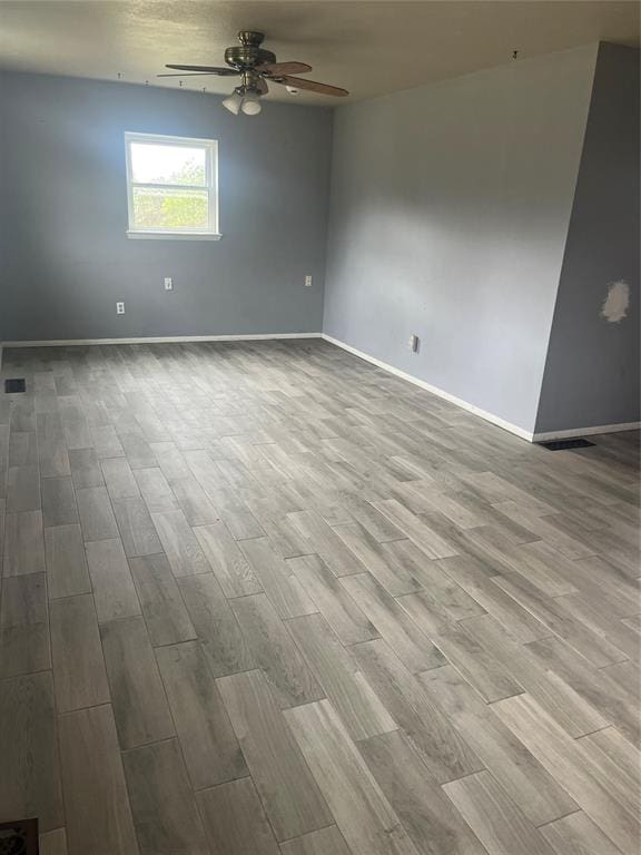 unfurnished room with light wood-type flooring and ceiling fan