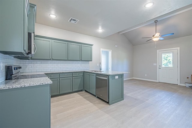 kitchen with kitchen peninsula, backsplash, stainless steel appliances, and lofted ceiling