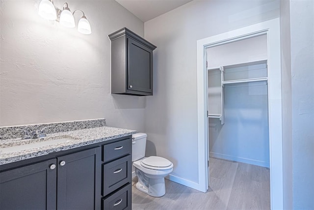 bathroom with hardwood / wood-style floors, vanity, and toilet