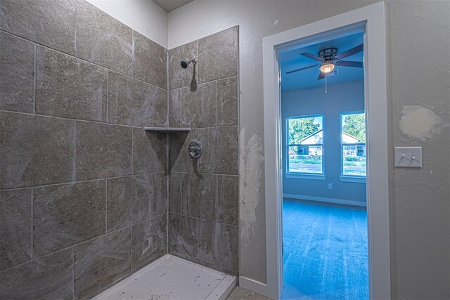 bathroom featuring a tile shower and ceiling fan