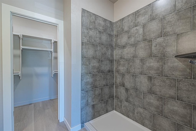 bathroom featuring hardwood / wood-style flooring and a tile shower