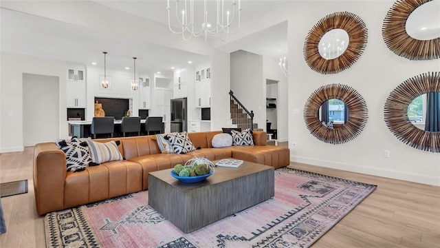 living room featuring hardwood / wood-style flooring, a high ceiling, and a chandelier