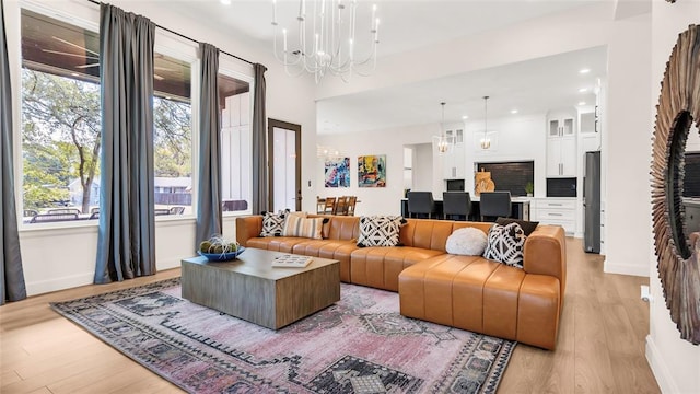 living room featuring light wood-type flooring and an inviting chandelier