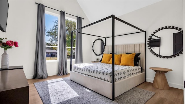 bedroom featuring hardwood / wood-style floors and lofted ceiling