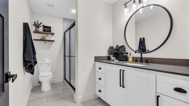 bathroom with tile patterned floors, vanity, toilet, and a shower with shower door