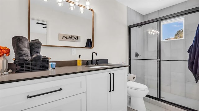 bathroom featuring vanity, tile patterned flooring, ceiling fan, toilet, and a shower with shower door