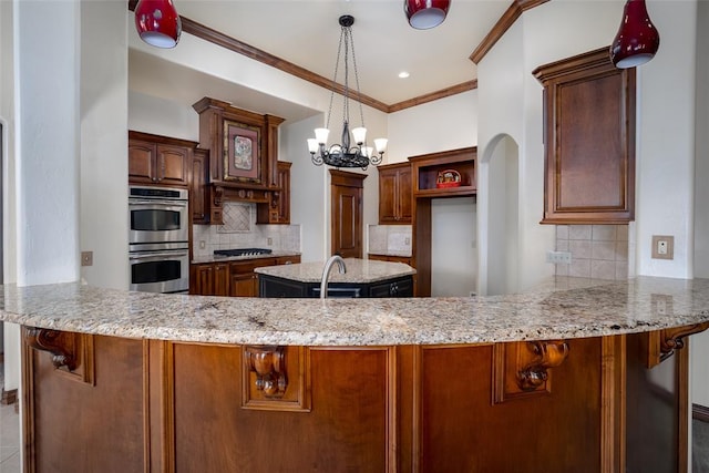 kitchen with an inviting chandelier, decorative backsplash, ornamental molding, double oven, and kitchen peninsula