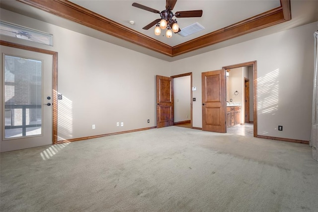 spare room featuring light carpet, a raised ceiling, ceiling fan, and ornamental molding