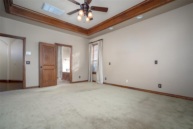 spare room with ceiling fan, light colored carpet, ornamental molding, and a tray ceiling