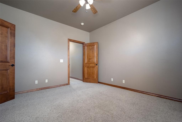 spare room with light carpet, ceiling fan, and vaulted ceiling