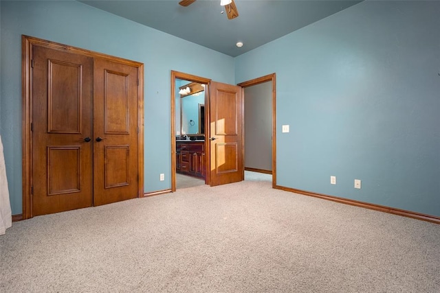 unfurnished bedroom featuring ensuite bath, ceiling fan, and light colored carpet