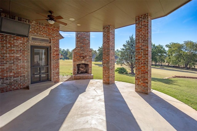 view of patio with ceiling fan and an outdoor brick fireplace