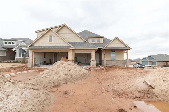 view of front of house featuring a garage and roof with shingles