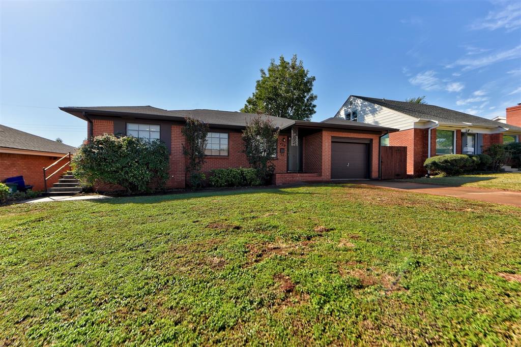 ranch-style home featuring a front yard and a garage