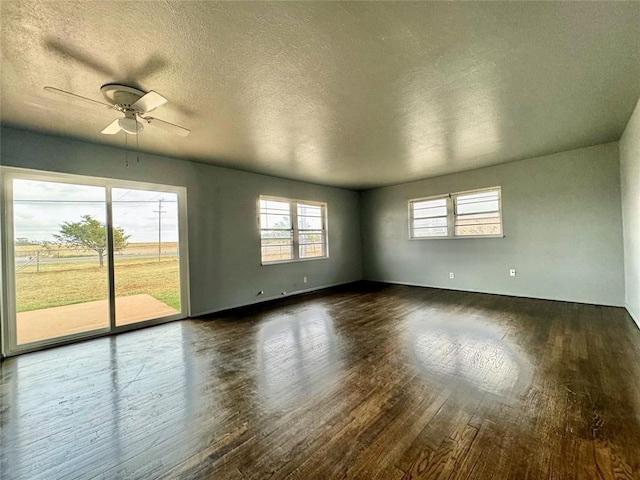 unfurnished room featuring a textured ceiling, ceiling fan, and dark wood-type flooring