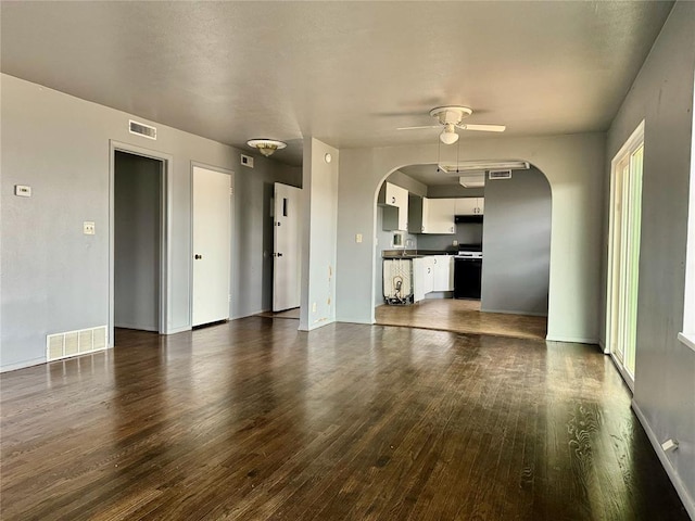 unfurnished living room with ceiling fan and dark wood-type flooring