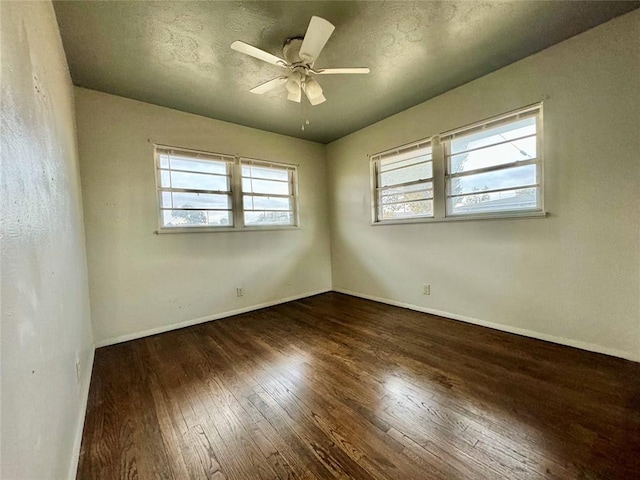 unfurnished room featuring ceiling fan, dark wood-type flooring, and a textured ceiling