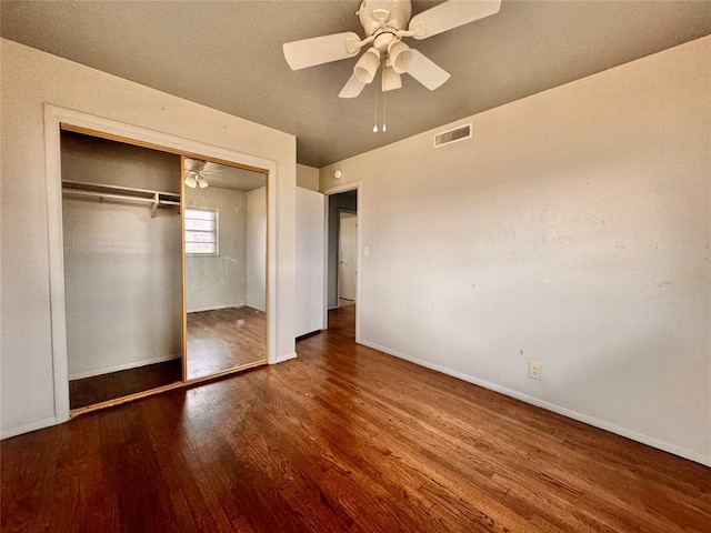 unfurnished bedroom with hardwood / wood-style floors, ceiling fan, and a closet