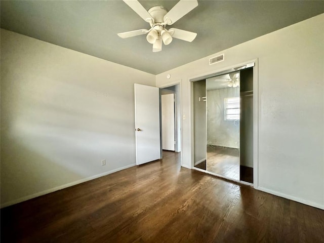 unfurnished bedroom featuring ceiling fan, dark hardwood / wood-style flooring, and a closet