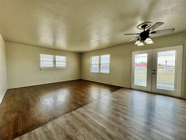 empty room with french doors, a textured ceiling, hardwood / wood-style flooring, and ceiling fan