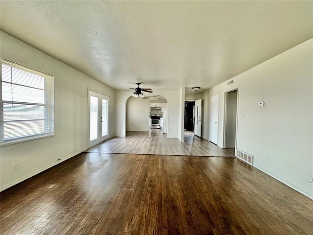 unfurnished living room with ceiling fan, french doors, a textured ceiling, and hardwood / wood-style flooring