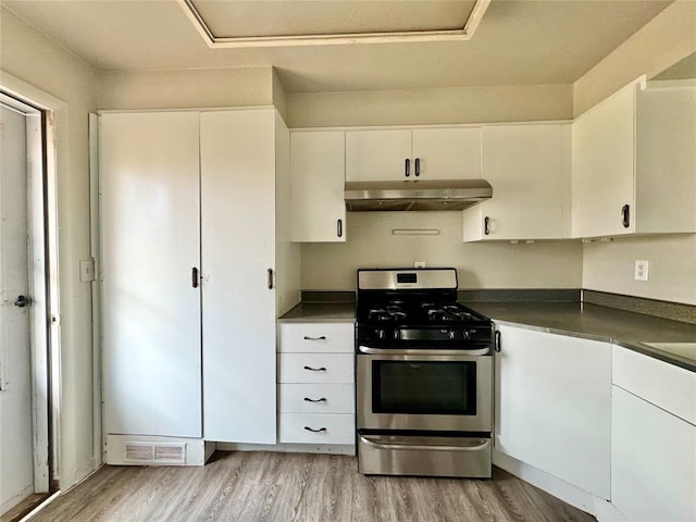 kitchen with light hardwood / wood-style flooring, white cabinets, and stainless steel range with gas stovetop