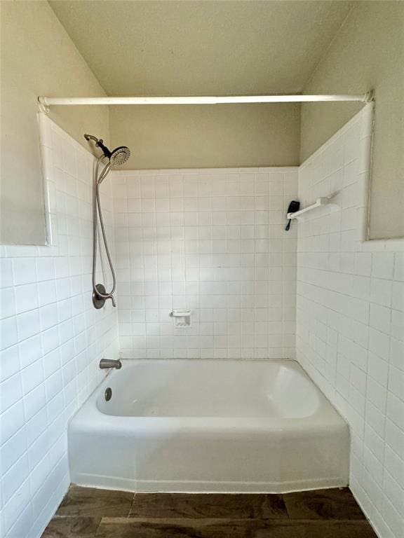 bathroom featuring tiled shower / bath and tile walls